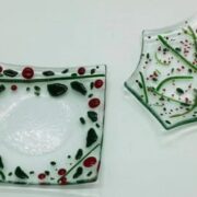 A pair of glass plates with red and green designs on them.