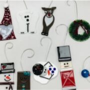 A group of christmas ornaments hanging on a white wall.