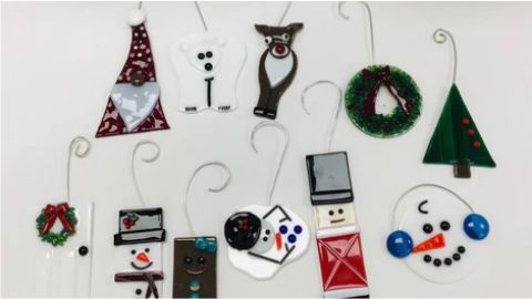 A group of christmas ornaments hanging on a white wall.