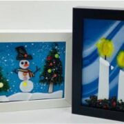 Two framed pictures with a snowman and a christmas tree.