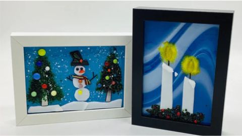 Two framed pictures with a snowman and a christmas tree.