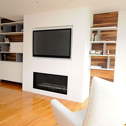 A living room with a tv and bookshelves.